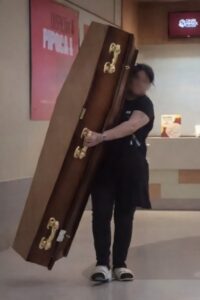 MULHER TENTA USAR CAIXÃO PARA PEGAR PIPOCA EM PROMOÇÃO DE CINEMA EM SP